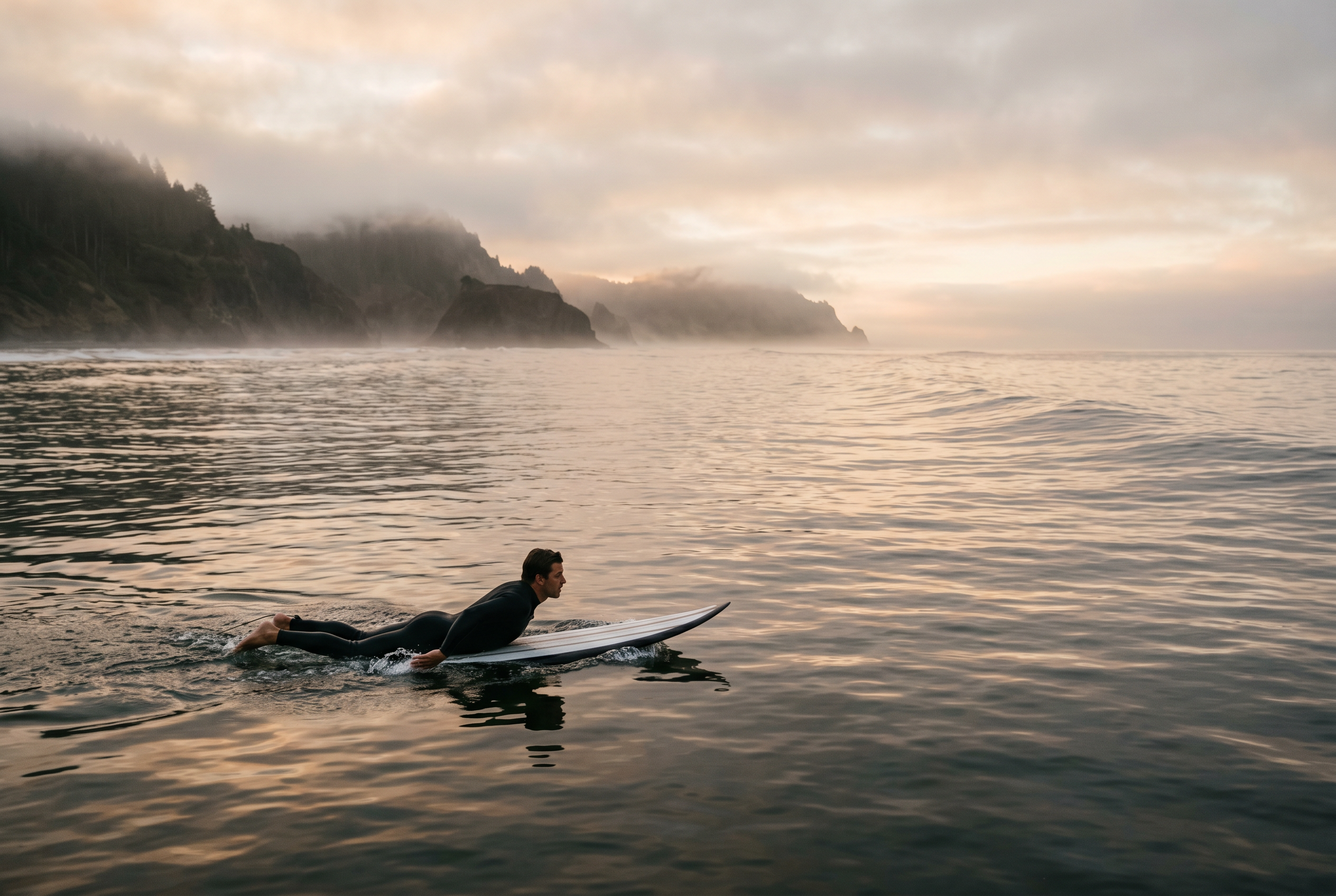 Surfista en neopreno premium cogiendo una ola al amanecer